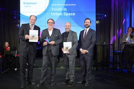 Gruppenfoto vier Männer auf einer Bühne