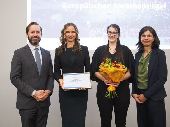 Menschen halten Blumen und Auszeichnung in die Kamera