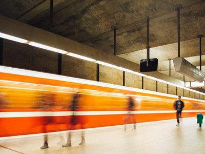 Menschen gehen an einem Bahnsteig entlang