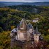 Luftbild einer Burg in Luxemburg in mitten von Wald.