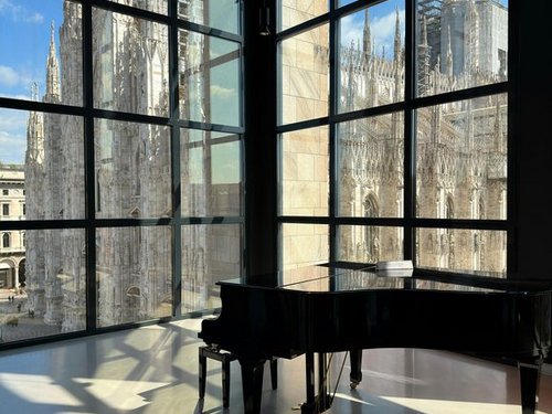Blick auf den Dom in Mailand hinter einer Glasfassade.