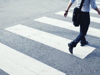  A man walks across a zebra crossing.