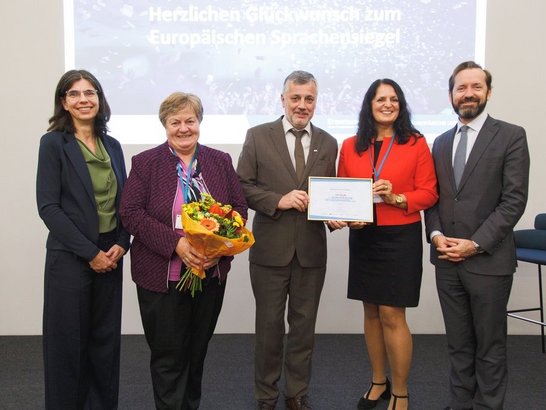 Menschen halten Blumen und Auszeichnung in die Kamera