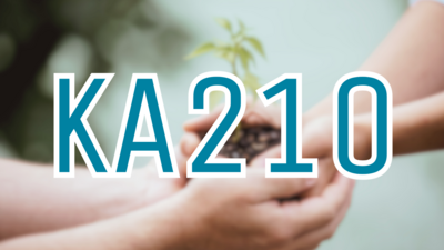 Zwei Hände halten im Hintergrund verschwommen eine Pflanze mit Erde. Im Vordergrund steht in Blau mit weißer Umrandung "KA210".