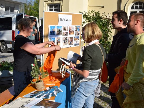 Junge Menschen und eine erwachsene Frau stehen an einem Stand