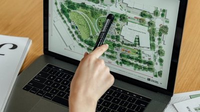 Eine Hand zeigt auf eine Darstellung auf einem Laptop.