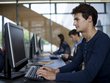 Ein junger Mann arbeitet an einem Desktop-Computer in einem modernen Computerraum