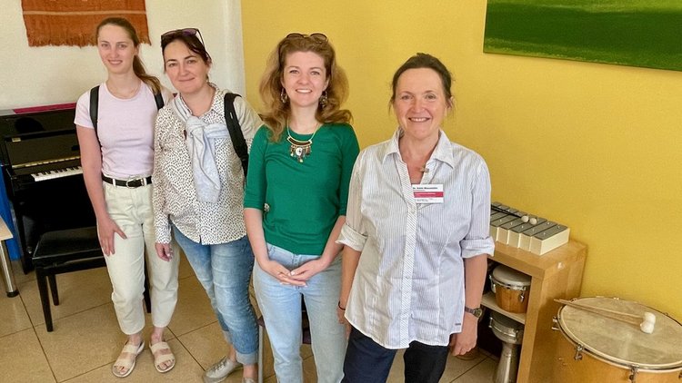 Das Bild zeigt vier Frauen in einem Raum mit verschiedenen Musikinstrumenten.
