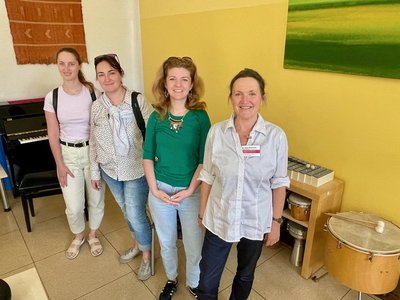Das Bild zeigt vier Frauen in einem Raum mit verschiedenen Musikinstrumenten.
