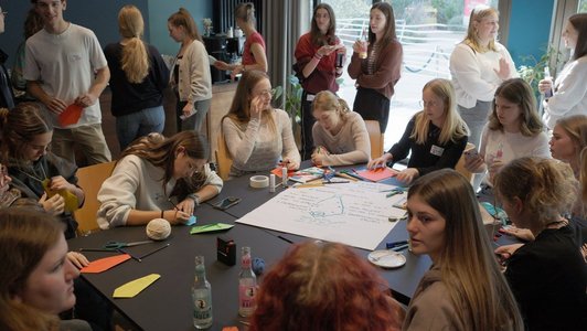 Gruppe junger Menschen sitzt im Kreis