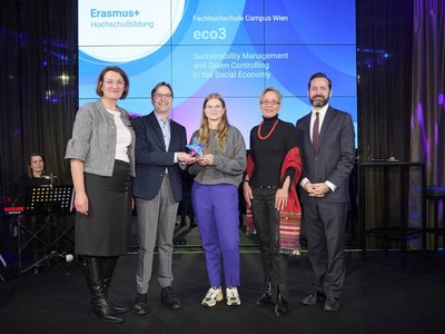 Europa bewegt: Erasmus+ und ESK Award 2024 Fünf Personen stehen auf der Bühne, dahinter auf dem Screen der Schriftzug „Erasmus+ Hochschulbildung - Fachhochschule Campus Wien – eco3“