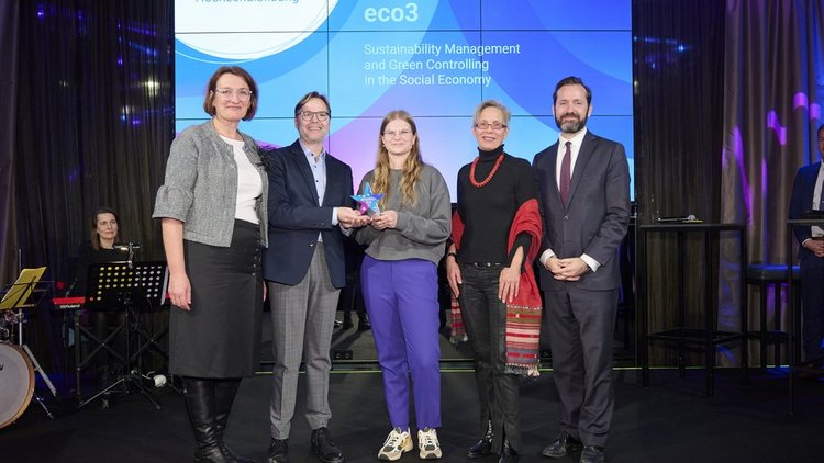 Europa bewegt: Erasmus+ und ESK Award 2024 Fünf Personen stehen auf der Bühne, dahinter auf dem Screen der Schriftzug „Erasmus+ Hochschulbildung - Fachhochschule Campus Wien – eco3“