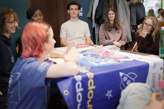 Junge Menschen sitzen im Kreis 