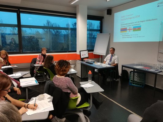 Group of sitting people looking at a presentation 