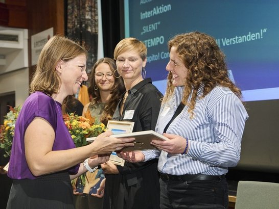 Gewinner:in bekommt Preis überreicht