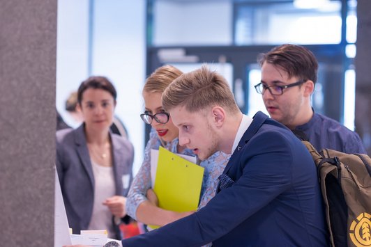 Junge Erwachsene stehen zusammen und schauen interessiert in eine Richtung 