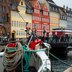 Ein Boot im Kanal von Kopenhagen vor einer bunten Häuserreihe. 