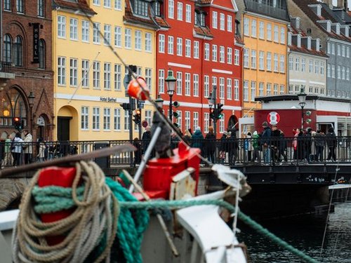 Ein Boot im Kanal von Kopenhagen vor einer bunten Häuserreihe. 