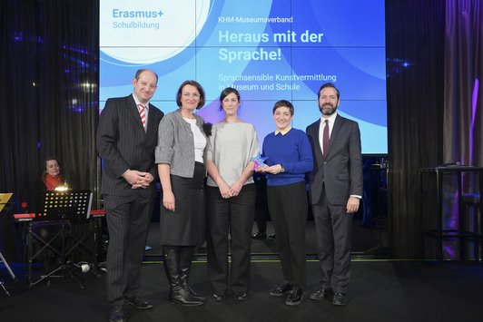 Gruppenfoto von drei Frauen und zwei Männern auf einer Bühne 