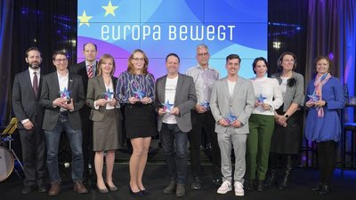 Gruppenfoto mit vielen glücklichen Menschen die bunte Sterntrophäen in der Hand halten