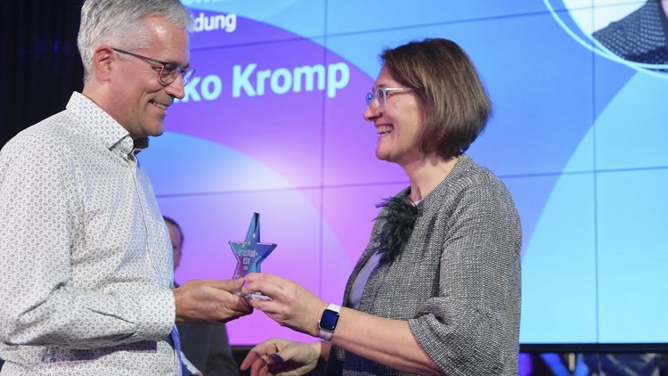 Frau gratuliert Mann und überreicht einen Award in Sternform