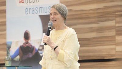 Helga Kromp-Kolb steht mit Mikrofon auf der Bühne, hinter ihr zu sehen ein Roll up mit der Aufschrift "OeAD Erasmus+"