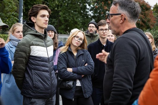 Junge Menschen hören altem Mann zu 