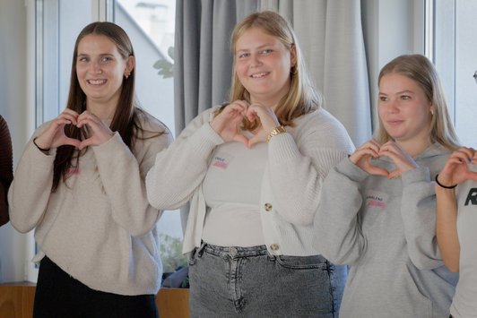 Drei Menschen formen Herz mit ihren Fingern