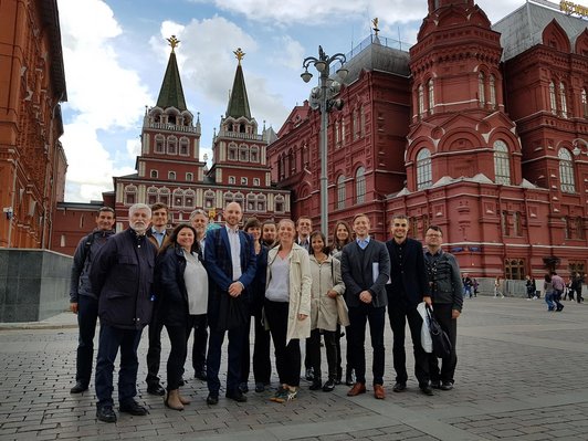 Gruppe von rund zehn Personen posiert für ein Foto auf dem roten Platz in Moskau