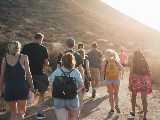 Gruppe von Jugendlichen beim Wandern in den Bergen, die Sonne scheint