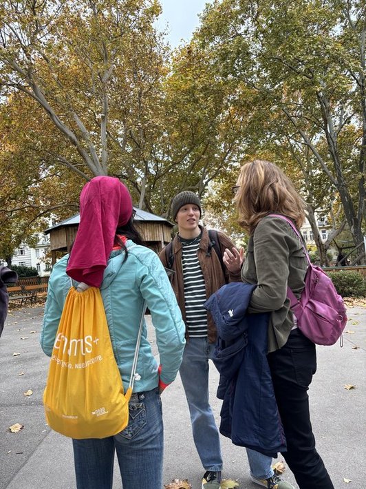 Drei Personen stehen in Park zusammen 