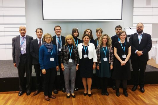 Organisers and guests of the seminar standing in front of the stage