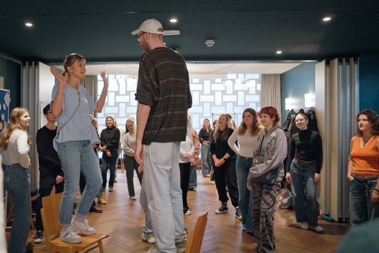 Gruppe junger Menschen steht im Raum 