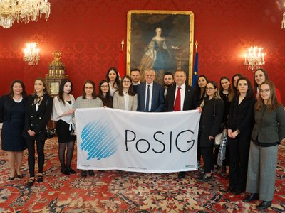 Eine Gruppe von etwa 15 internationalen Studierenden posiert gemeinsam mit Herrn Bundespräsident Van der Bellen für ein Foto.