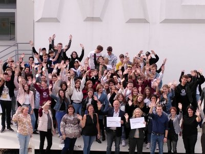 Foto der Klasse die am Projekt teilgenommen hat. Alle Schülerinnen und Schüler winken mit den Händen