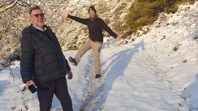 Zwei Männer vor ein verschneiten Landschaft, sie lächeln in die Kamera