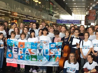 Gruppenfoto mit Schulkindern, die einen Banner mit dem Wort Erasmus halten. 