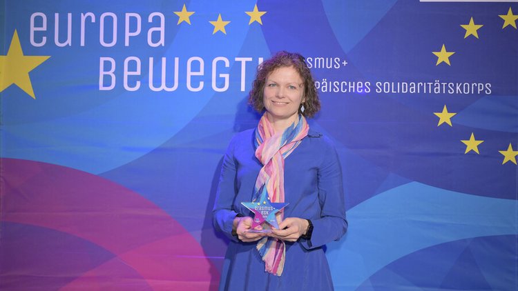 Frau mit Locken hält Preis