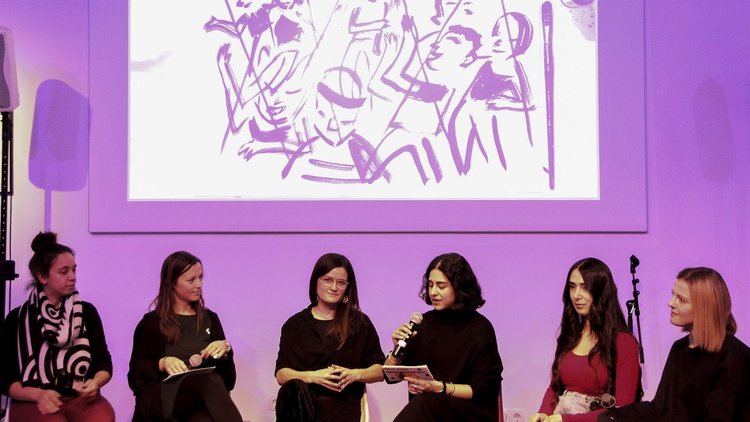 Sechs Frauen sitzen in einer Diskussionsrunde auf der Bühne
