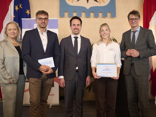 Drei Männer und zwei Frauen lachen in die Kamera