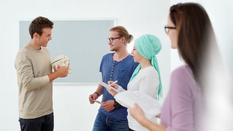 Junge Erwachsene stehen zusammen und unterhalten sich 