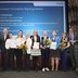 Gewinner:innen EITA 2026: Gruppe an Menschen steht auf der Bühne und lacht in die Kamera