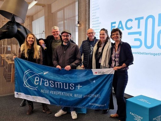 Gruppe an Menschen halten Erasmus+ Banner