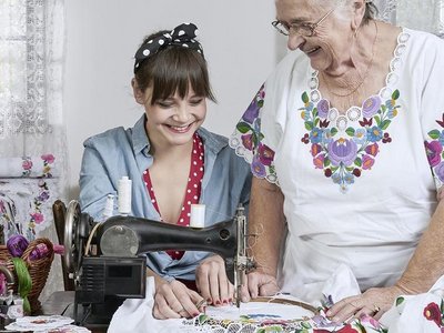 Junge Frau lernt Stickarbeit von einer älteren Frau