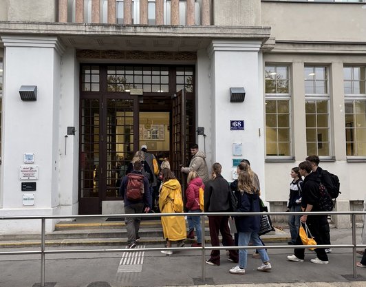 Personen gehen in ein Schulgebäude