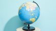 Globus steht vor einer hellblauen Wand auf einem kleinen, runden Tisch mit weißer Tischplatte