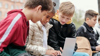 Drei Kinder vor einem Laptop sitzend