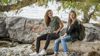 Zwei junge Frauen sitzen auf einem Felsen