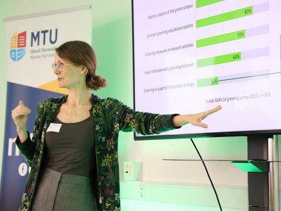 Das Foto zeigt eine Frau bei einem Vortrag zu ihrem Projekt.