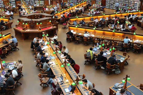 Studierende an Tischen in Bibliothek von oben fotografiert